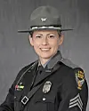 State trooper in uniform smiling for a portrait.