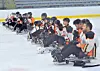 Sled hockey players sitting on the ice during practice.