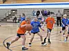 Children playing basketball in a gymnasium.