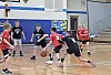 Children playing basketball in a gymnasium.