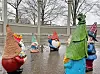 Colorful garden gnomes in a gazebo on a rainy day.