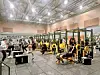 Athletes training in a gym with weightlifting equipment.