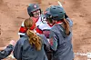 Softball players celebrate a successful play.