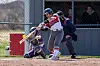 Softball player swings at a pitch during a game.