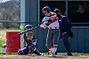 Softball player swinging at a pitch with a catcher behind her.