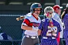 Two softball players smiling and celebrating on the field.
