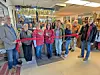 Group of people at a ribbon cutting ceremony inside a store.