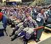 Students in military attire seated in an auditorium.