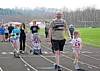 Participants walking on a track during a community event.