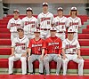 Baseball team in uniforms on red bleachers.