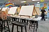 Art studio with blank canvases and participants preparing to paint.