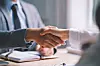 Handshake between two professionals in a meeting.