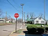 Stop sign on a residential street with houses in the background.