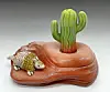 Ceramic armadillo and cactus sculpture.