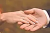 Couple's hands with wedding rings in a natural setting.