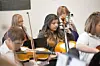 Students playing string instruments in a music class.