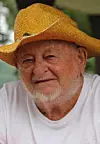 Elderly man in a straw hat and white shirt.
