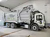 Garbage truck inside a maintenance facility.