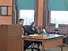 Two individuals seated at a courtroom table.