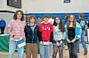Five students posing together at a school event.