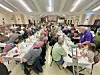Crowd of people seated at tables in a banquet hall.