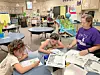 Children and a teacher working together in a classroom.