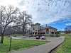 Historic building with trees and a blue sky in the background.