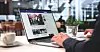 Person typing on a laptop in a café with a coffee cup.