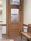 Wooden courtroom door with frosted glass panel.