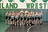Youth wrestling team in uniforms at Midland Wrestling facility.