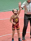 Young wrestler celebrates victory with raised hand.