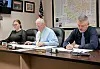 Local government officials seated at a table during a meeting.