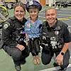 Two police officers with a child in a police costume.