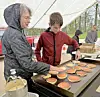 Two volunteers cooking pancakes on a griddle.
