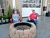 Two people sitting by a fire pit in an outdoor setting.