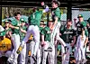 Baseball players celebrate in the dugout.