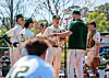 Baseball team meeting with coach on the field.