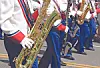 Marching band members playing instruments in a parade.