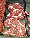 Marbled beef cuts in a butcher shop display.