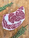 Marbled beef with thyme on a cutting board.