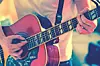 Close-up of a musician playing an acoustic guitar.