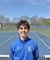 Smiling young male tennis player on a court.