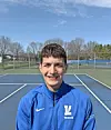 Smiling young athlete on a tennis court.