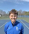Young athlete smiling on a tennis court.