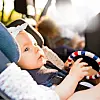 Baby in a car seat holding a toy.