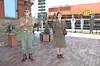 Two historical reenactors in World War II uniforms at a train station.