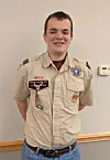 Young man in Boy Scouts uniform with badges.