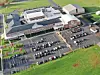 Aerial view of a school with parking lot and green fields.
