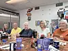 Five seniors seated at a diner table with drinks.