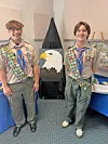 Two Eagle Scouts stand beside an eagle painting.